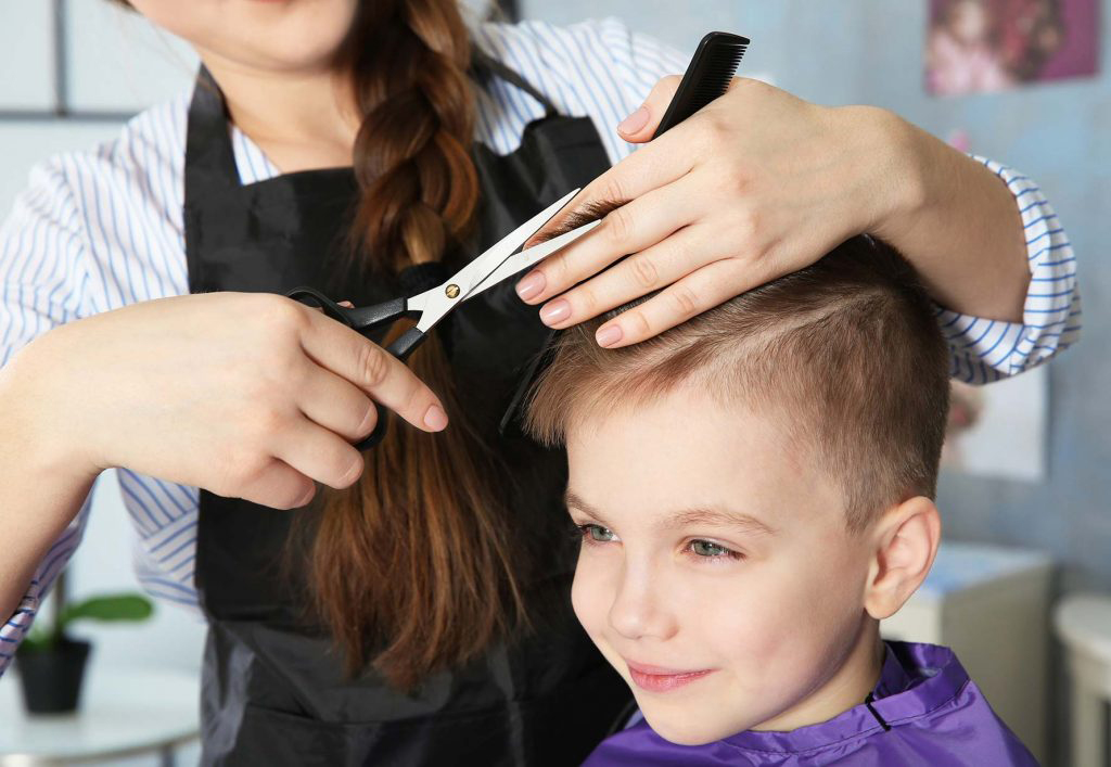 Kind beim Haarschnitt im Salon